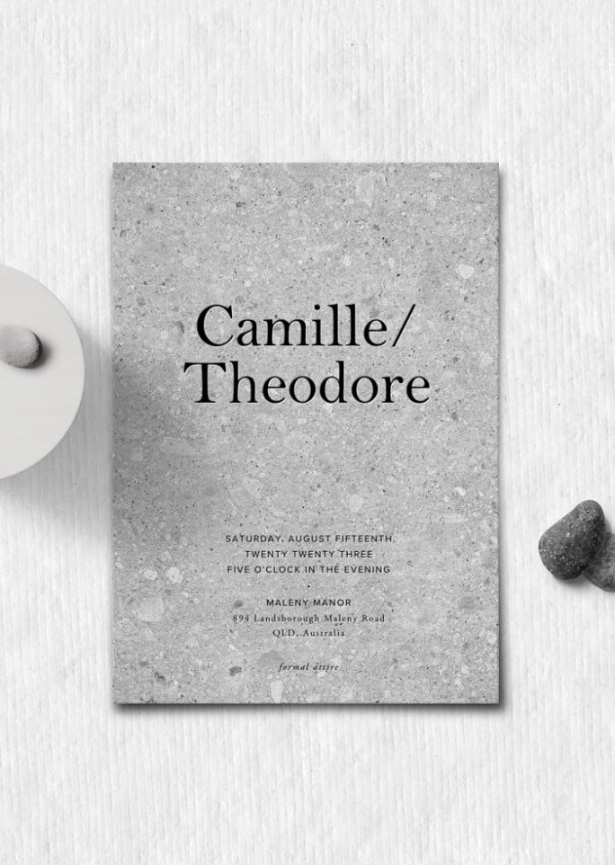 A gray wedding invitation for a couple named Camille and Theodore